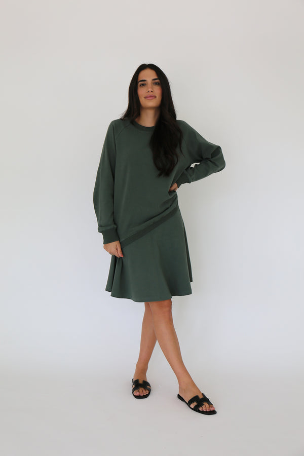 Front facing model wearing a cotton spandex pullover with matching skirt in forest green