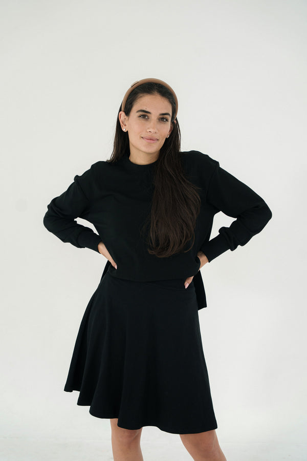 Woman wearing a black outfit against a white background