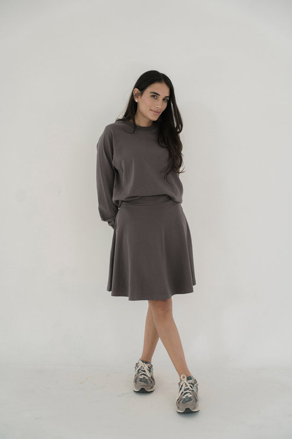 Woman wearing a grey outfit on a white background