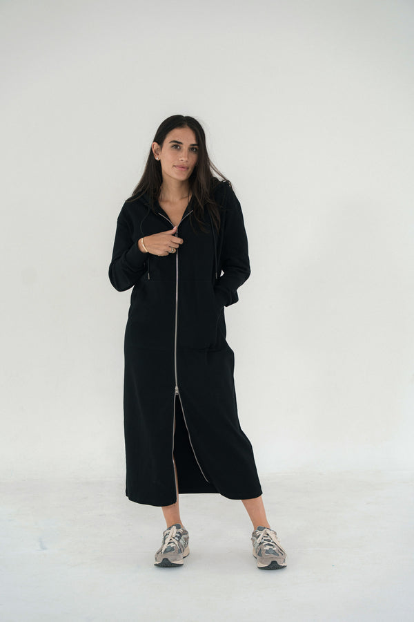 Woman wearing a black zip-up dress on a white background