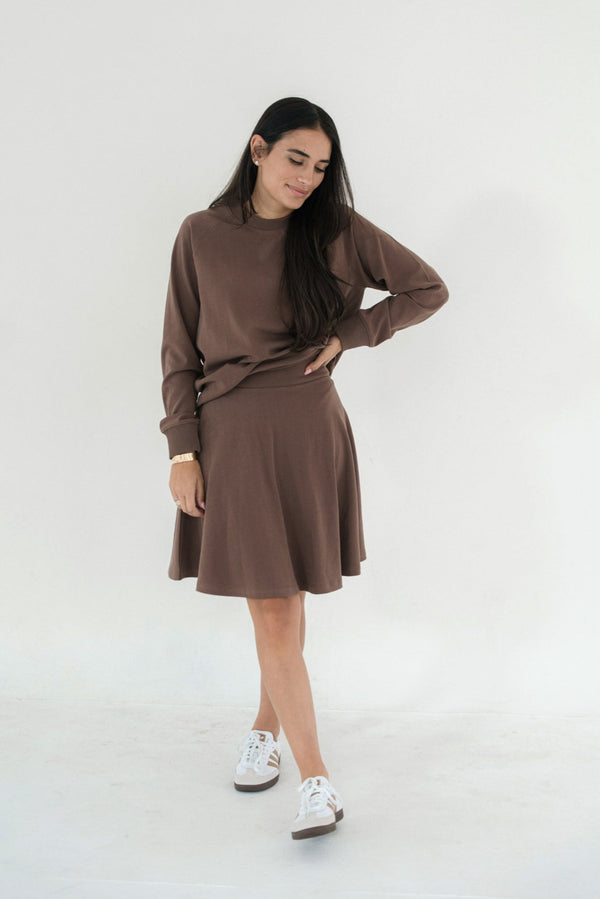 Woman wearing a brown outfit with a white background