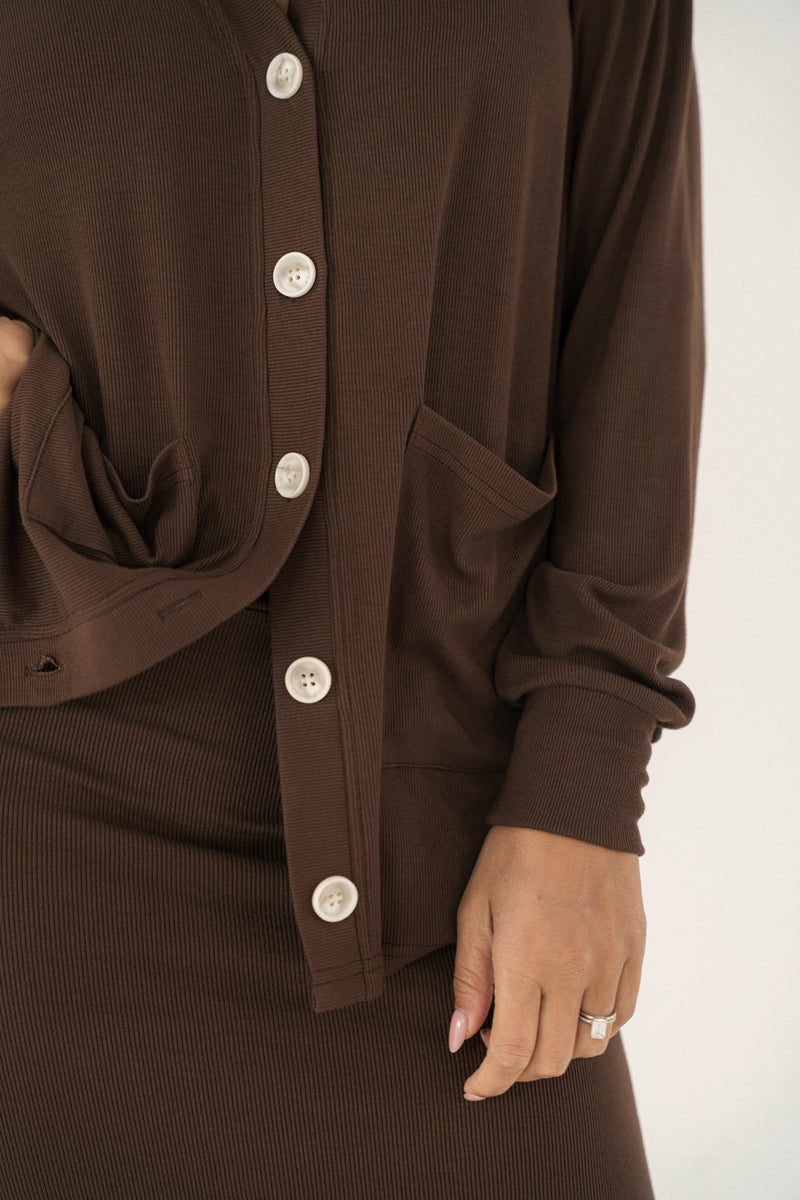 Brown cardigan with button details on a white background